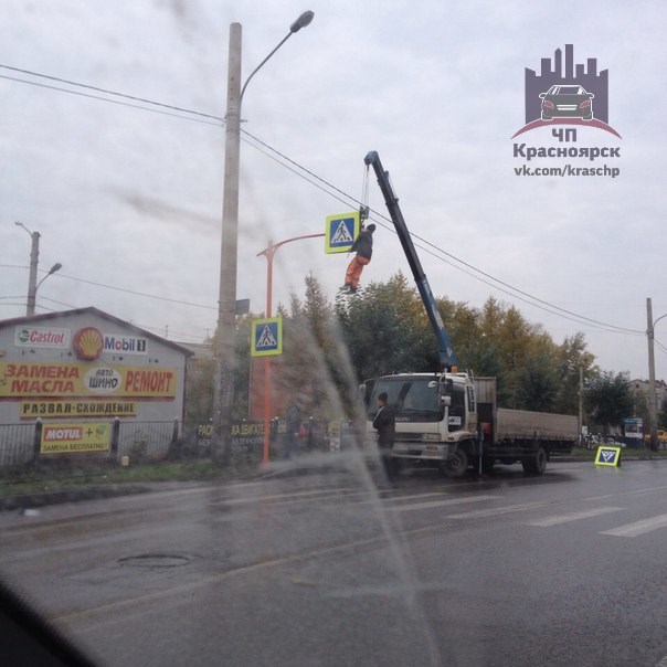 В Красноярске мужчина монтировал дорожные знаки при помощи крана без люльки